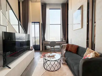Modern living room with high ceilings, large windows, and stylish decor in a luxury apartment.