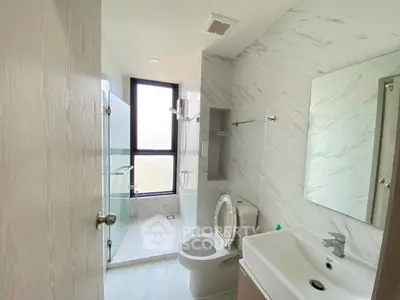Modern bathroom with glass shower and large window in stylish apartment