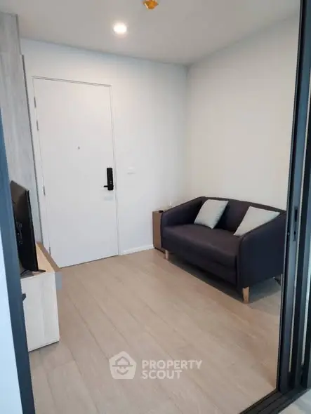 Cozy modern living room with sleek sofa and TV, perfect for relaxation.