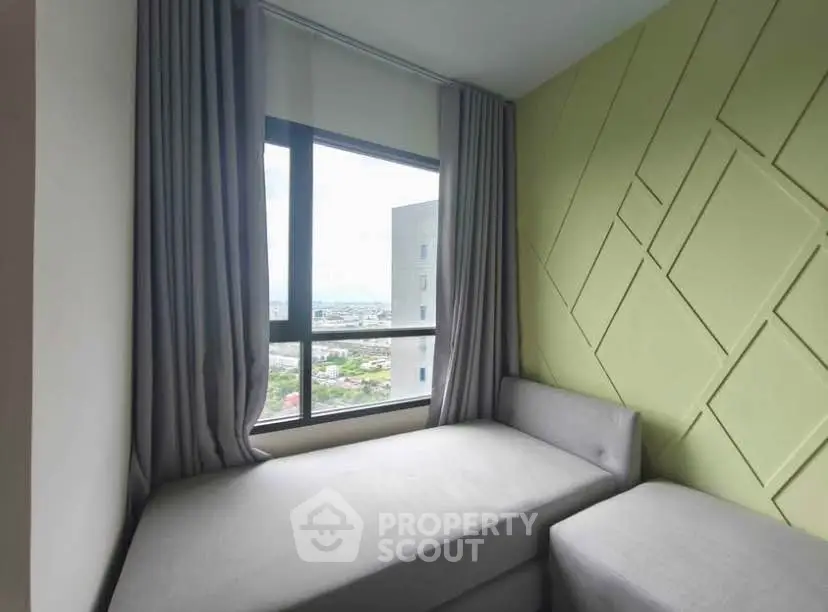 Cozy corner unit with modern decor and expansive city view through large window.