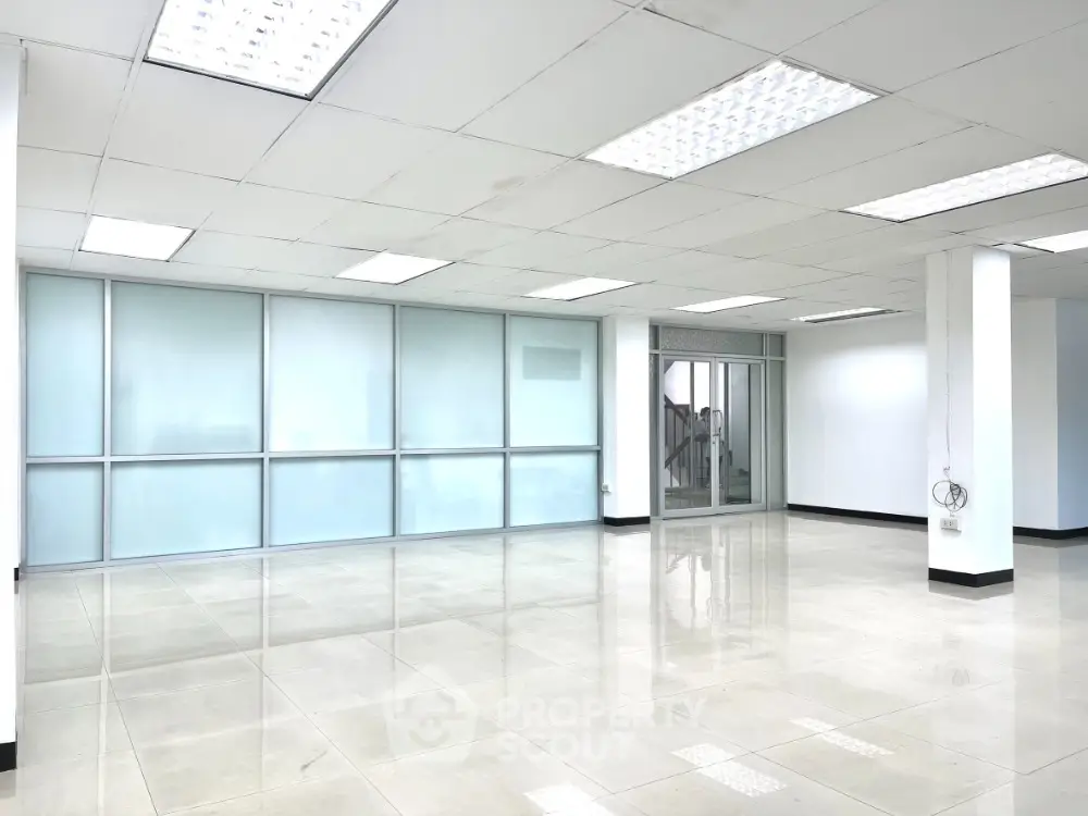Spacious modern office space with large windows and bright lighting