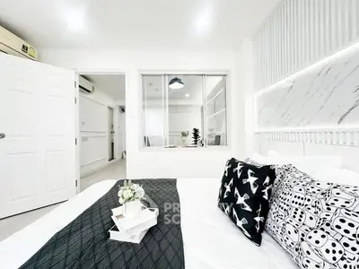 Modern bedroom with stylish decor and elegant lighting, featuring a cozy bed and chic wall design.