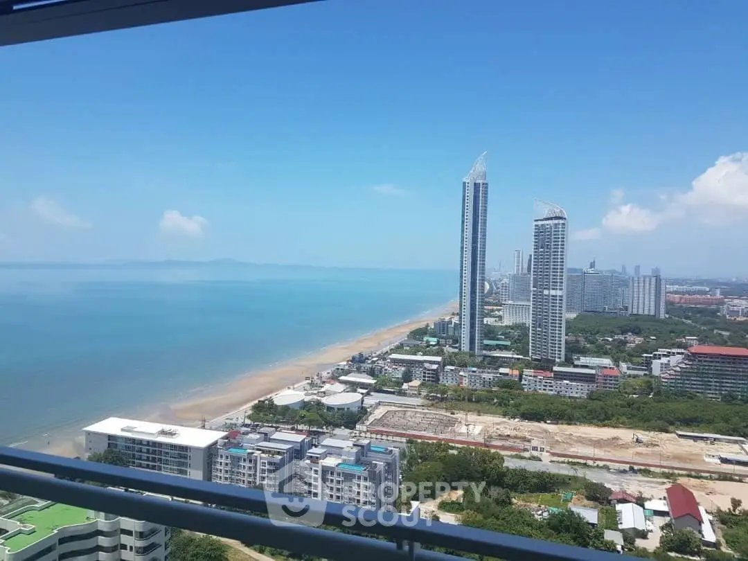 Stunning beachfront view from high-rise balcony overlooking city skyline and ocean.