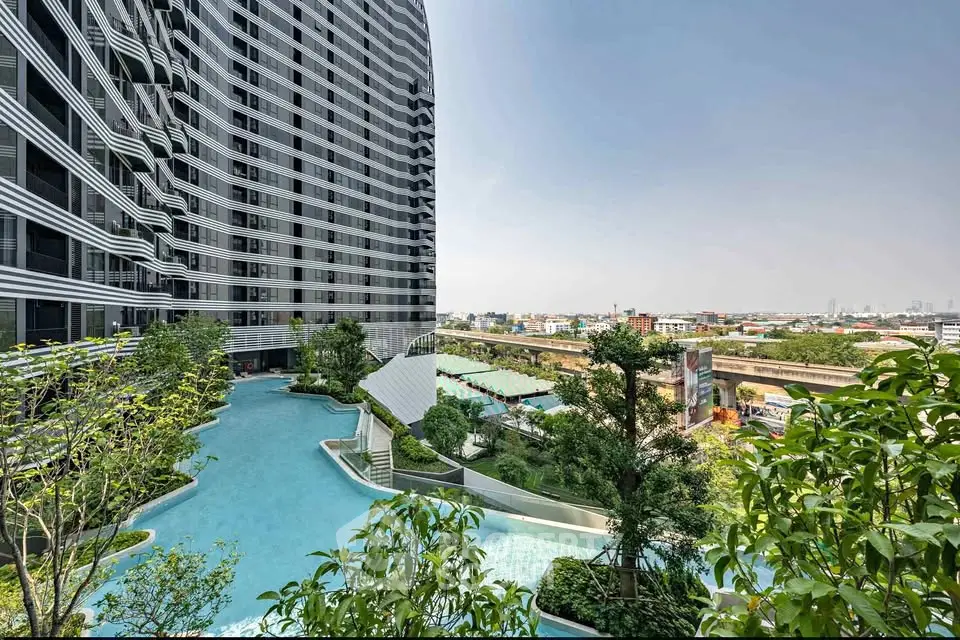 Luxurious high-rise building with stunning pool and city view, perfect for urban living.