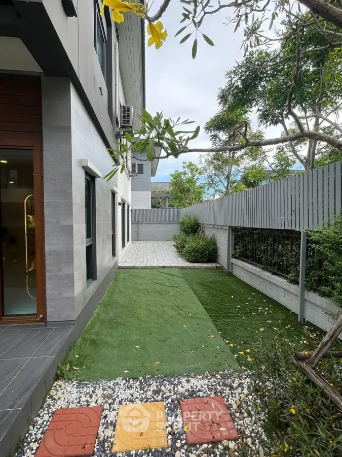 Modern residential backyard with artificial grass and stone pathway