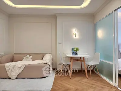 Modern living room with cozy sofa and dining area, featuring elegant lighting and stylish decor.