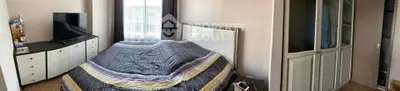 Spacious bedroom with modern decor and ample storage space, featuring a large window for natural light.