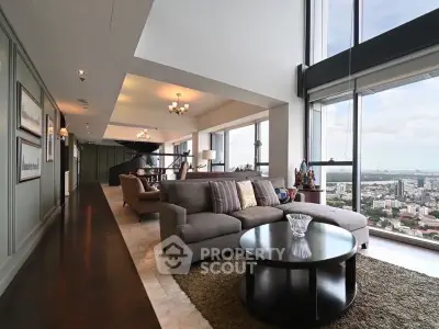 Luxurious living room with panoramic city views and elegant furnishings in a high-rise apartment.