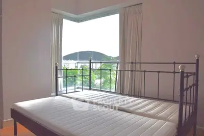 Spacious bedroom with large window offering scenic views