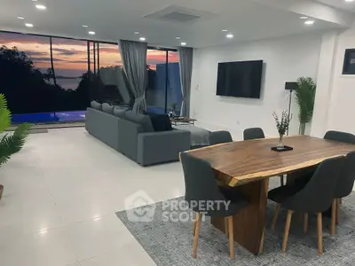 Luxurious open-plan living room with stunning sunset view and modern furnishings.