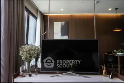 Modern living room with sleek TV, elegant decor, and ambient lighting.