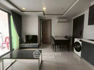 Modern living room with sleek furniture and integrated appliances in a stylish apartment.
