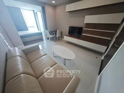 Modern living room with sleek furniture and large windows offering natural light.