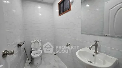 Modern bathroom with sleek fixtures and white tiled walls.