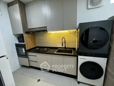 Modern kitchen with sleek cabinetry, gas stove, and integrated appliances in a compact layout.