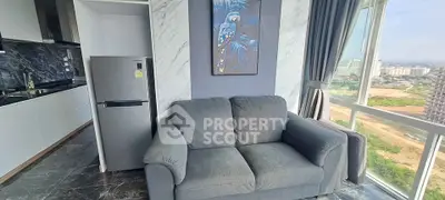 Modern living room with city view, featuring sleek kitchen and cozy sofa.