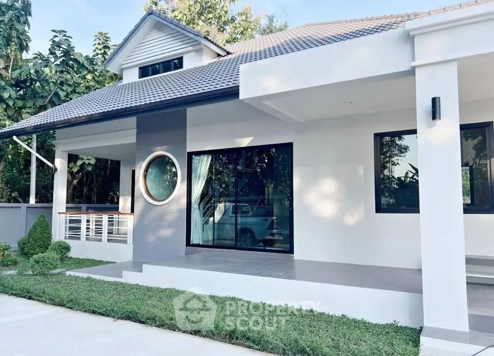 Modern single-story house with large windows and landscaped garden