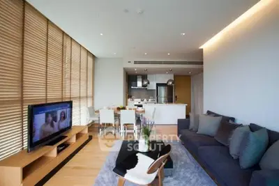 Modern living room with open kitchen, stylish decor, and natural light.