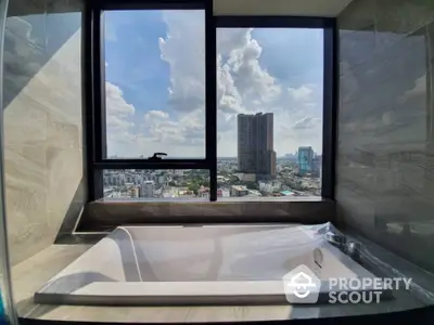 Luxurious bathroom with bathtub offering stunning city view through large window.