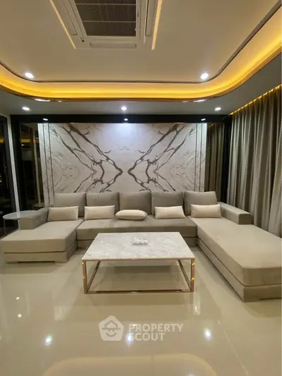 Luxurious modern living room with elegant marble accents and plush seating, perfect for sophisticated gatherings.