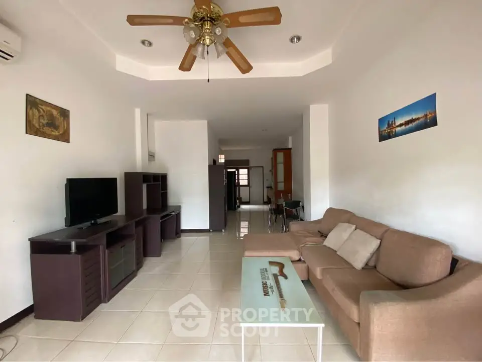 Spacious living room with modern furniture and ceiling fan