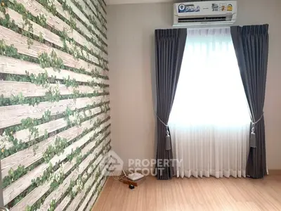 Bright room with unique wall design and large window with curtains.