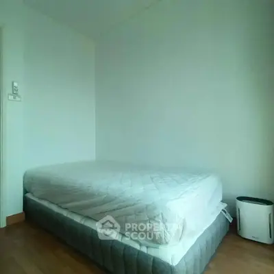 Minimalist bedroom with simple bed and air purifier, perfect for a cozy living space.