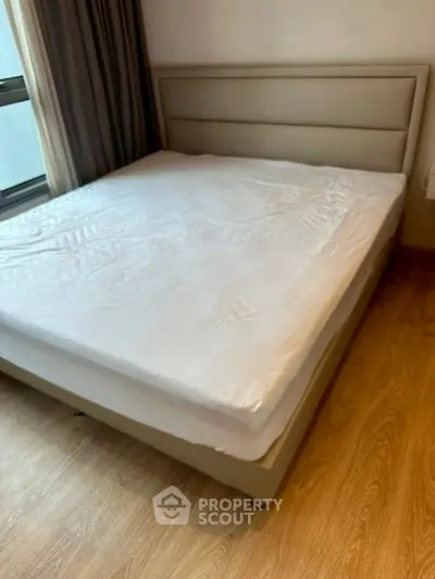 Spacious bedroom with modern bed and wooden flooring, perfect for comfort and style.