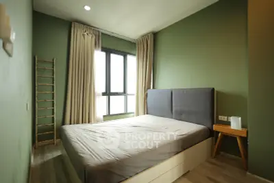 Modern bedroom with green walls, large window, and stylish decor in a cozy apartment.