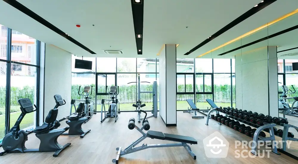 Modern gym with state-of-the-art equipment and large windows for natural light.