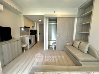 Modern studio apartment with open layout, featuring a cozy living area and compact kitchen.