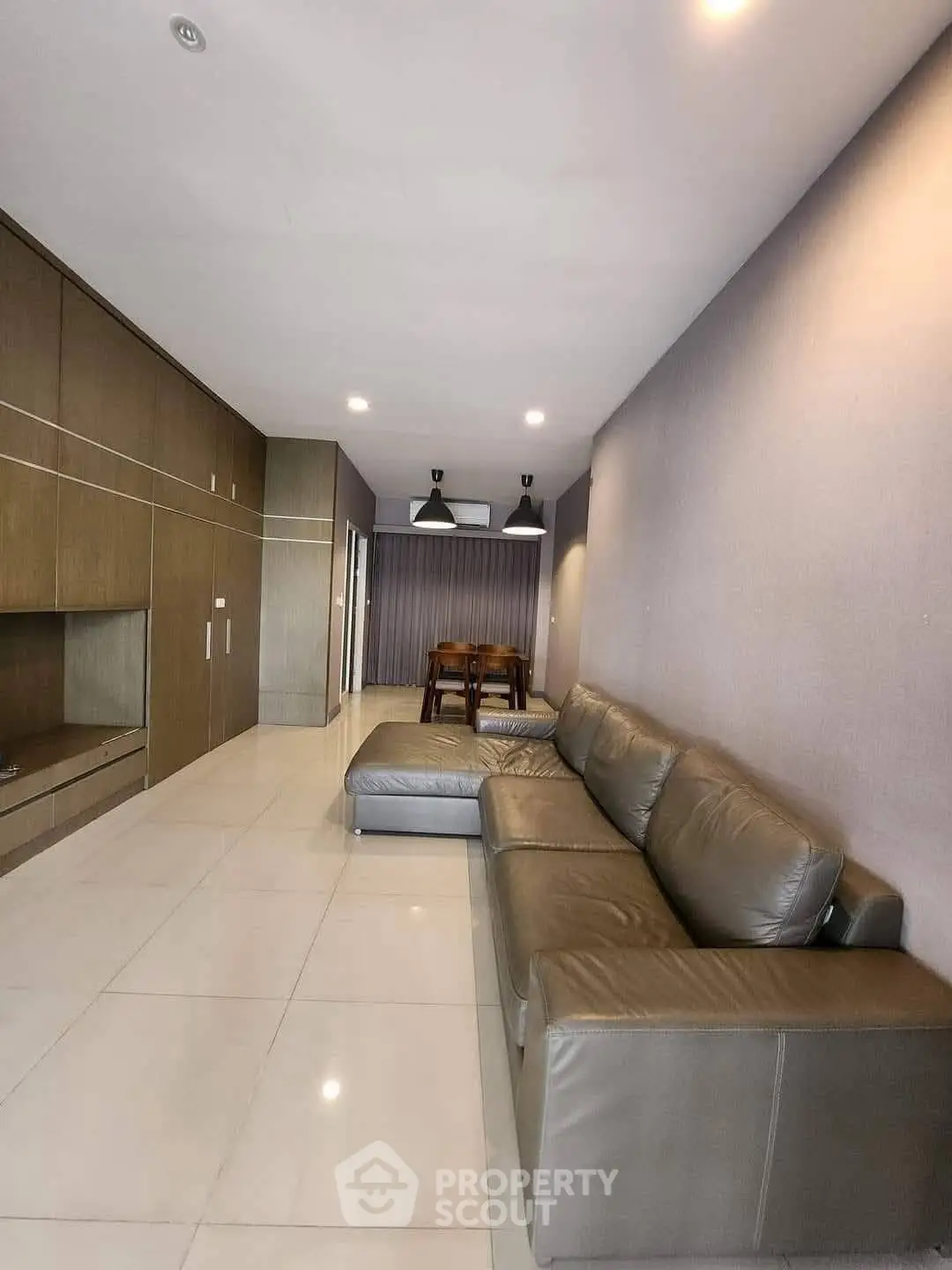 Spacious modern living room with sleek leather sofa and elegant dining area.