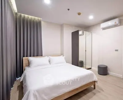 Modern bedroom with sleek design, featuring a comfortable bed and mirrored wardrobe in a cozy setting.