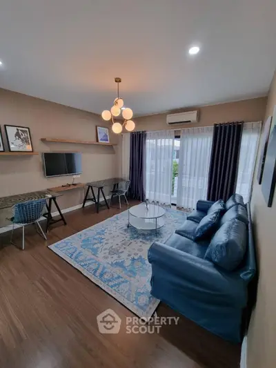 Modern living room with stylish decor, blue sofa, and large window for natural light.