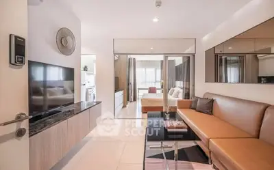 Modern living room with sleek design and open view to bedroom, featuring stylish furniture.