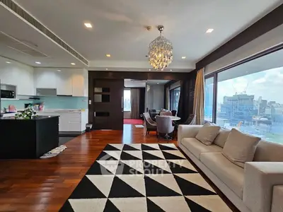 Luxurious open-plan living room with stunning city view and elegant chandelier