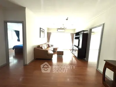 Spacious living room with wooden flooring and natural light