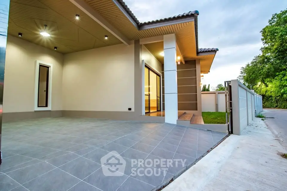 Modern single-story home with spacious driveway and lush greenery, perfect for serene living.