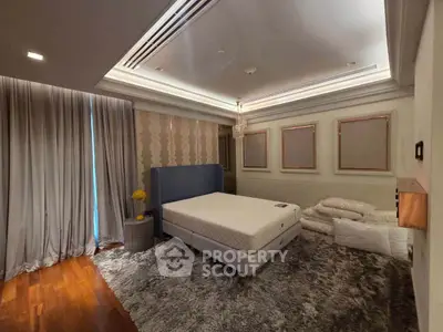 Luxurious bedroom with elegant decor and plush carpeting, featuring a stylish bed and ambient lighting.