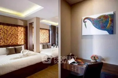 Luxurious bedroom with elegant decor and cozy study nook, perfect for relaxation and productivity.