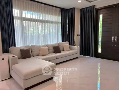 Spacious modern living room with elegant sofa and large windows for natural light.