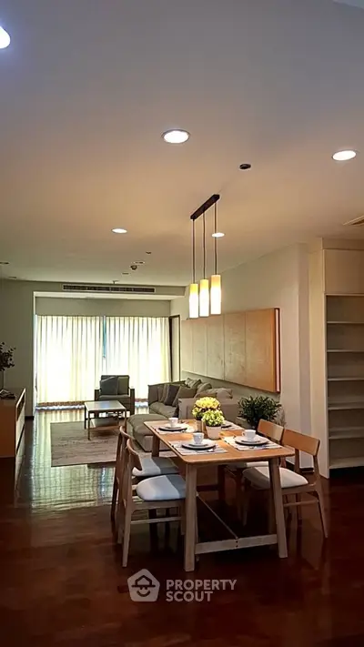 Spacious open-plan living and dining area with elegant lighting and modern furnishings.
