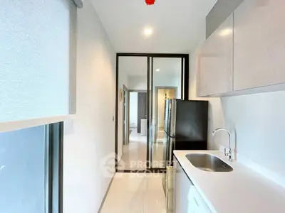 Modern kitchen with sleek design and stainless steel appliances in a bright apartment.