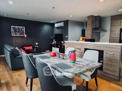 Modern open-plan living room and kitchen with stylish decor and wooden flooring.
