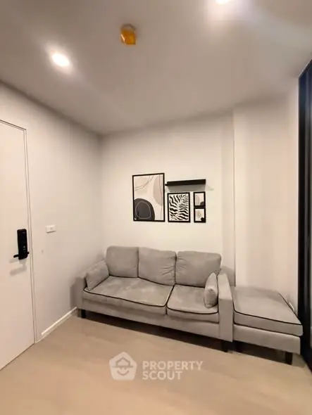 Modern living room with stylish gray sofa and contemporary wall art in a cozy apartment.