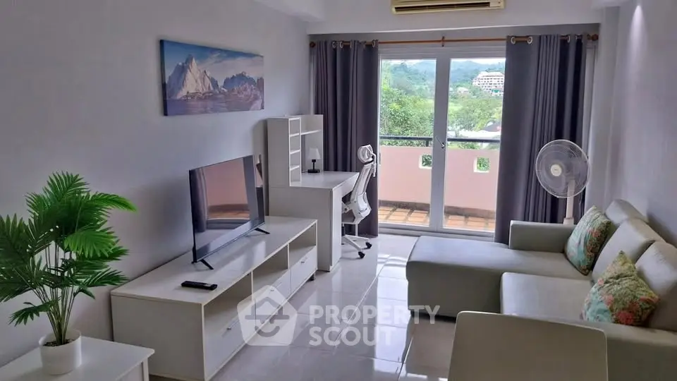 Modern living room with balcony view, stylish furniture, and natural light.