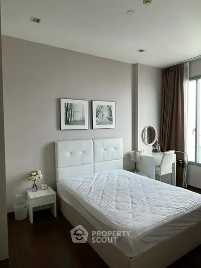 Modern bedroom with elegant decor and natural light, featuring a stylish bed and workspace.