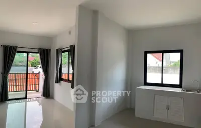 Spacious modern living area with large windows and balcony access