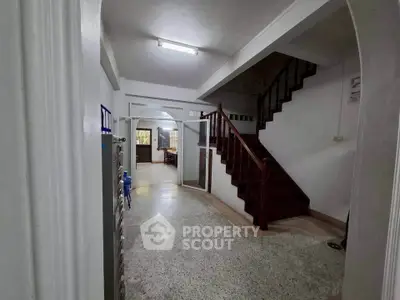 Spacious interior hallway with staircase and natural light, ideal for family living.
