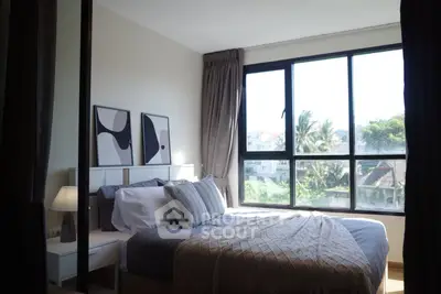 Bright and cozy bedroom with large window and modern decor, offering a serene view of lush greenery.